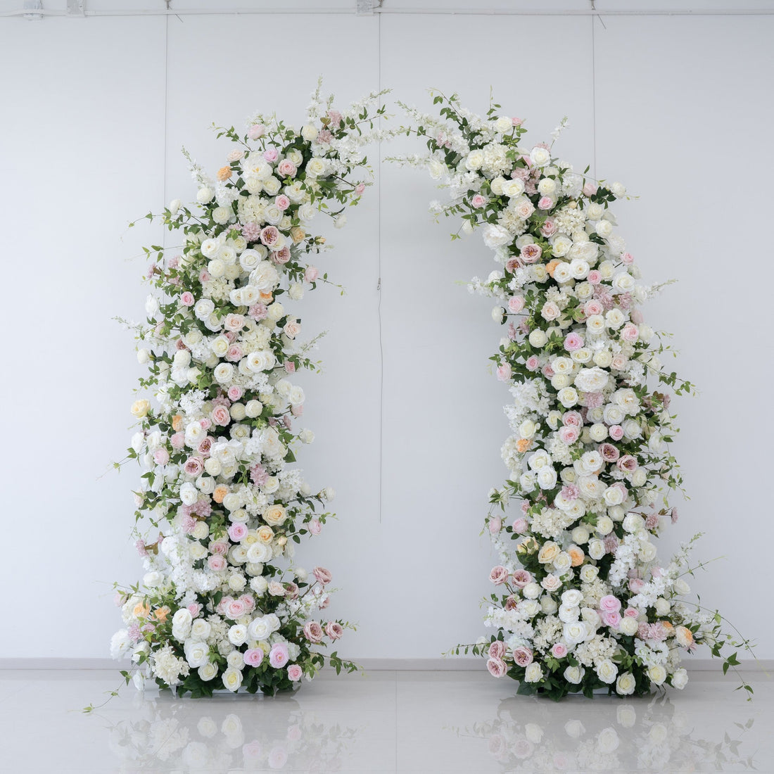 White and pink floral wedding arch used as a romantic backdrop
