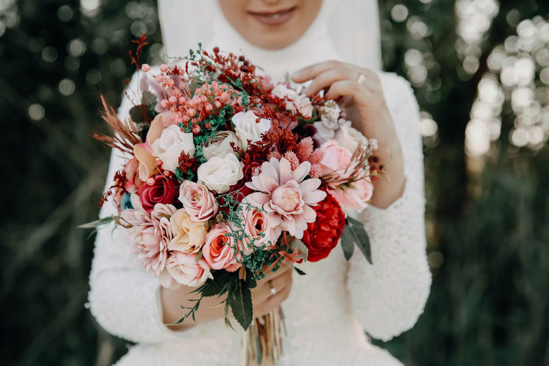 Bride holding a colorful wedding bouquet; editorial inspiration photo, not a Rosy Flower Wall product or client event.