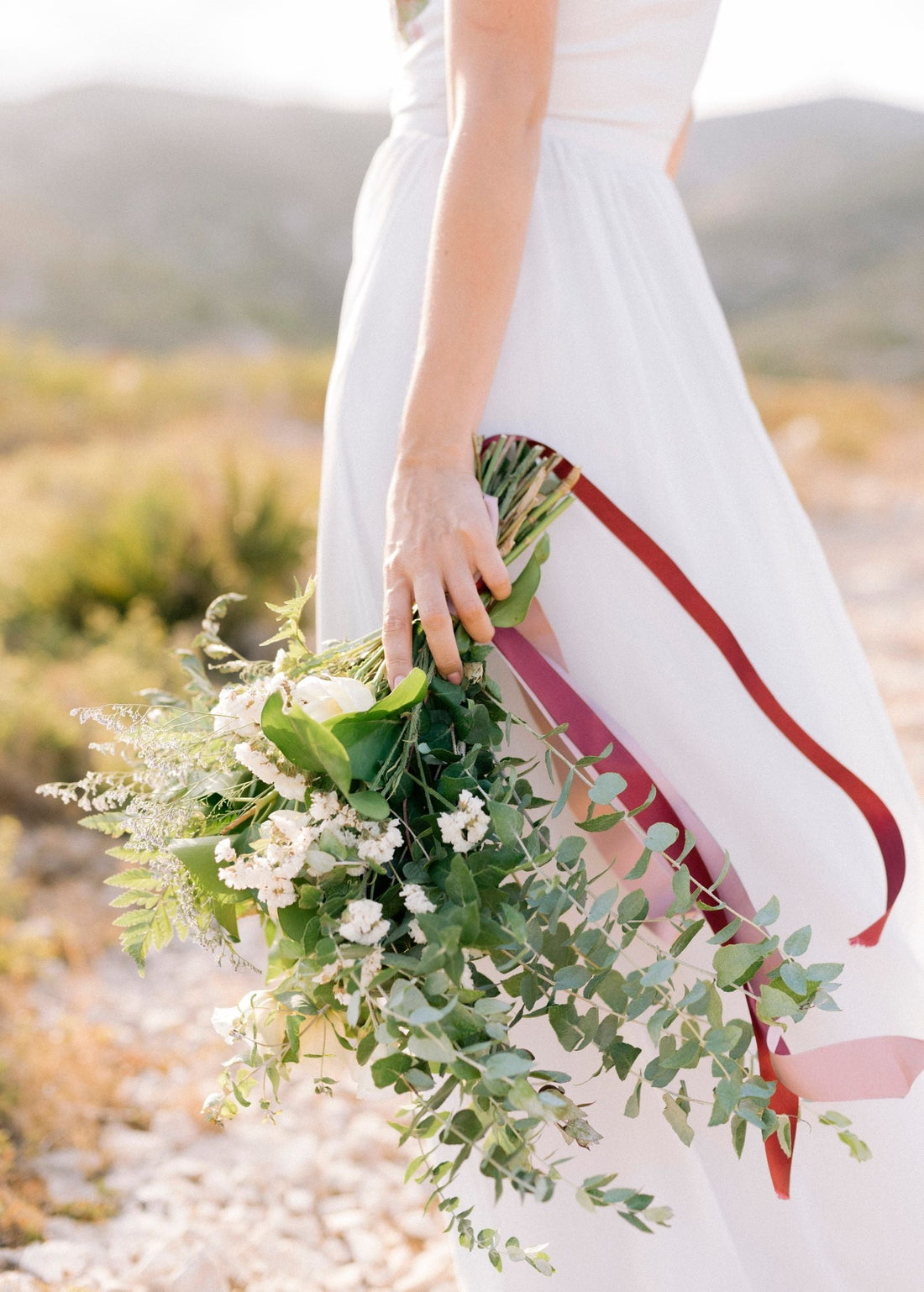 Bride holding a pastel bouquet outdoors at a wedding; editorial inspiration photo, not a Rosy Flower Wall product or client event.