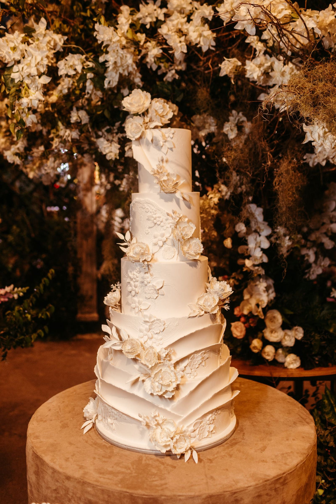 Five-tier wedding cake with white flowers; editorial inspiration photo, not a Rosy Flower Wall product or client event.