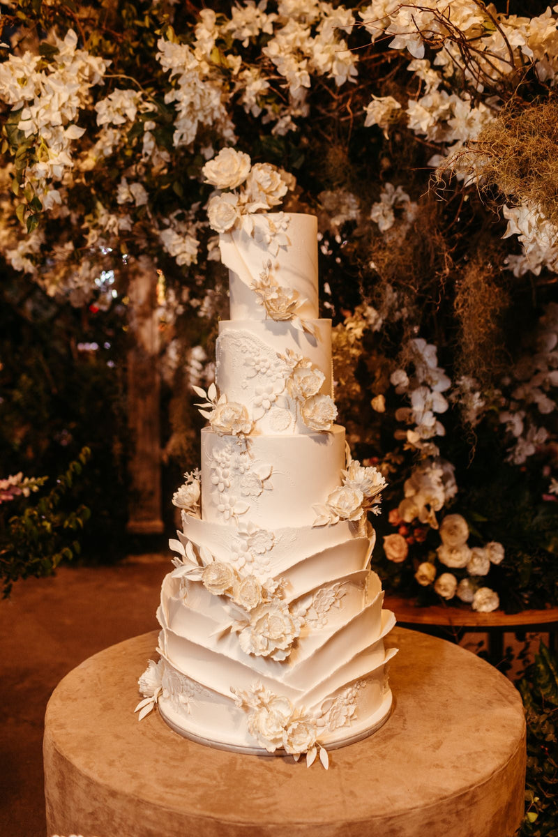 Five-tier wedding cake with white flowers; editorial inspiration photo, not a Rosy Flower Wall product or client event.