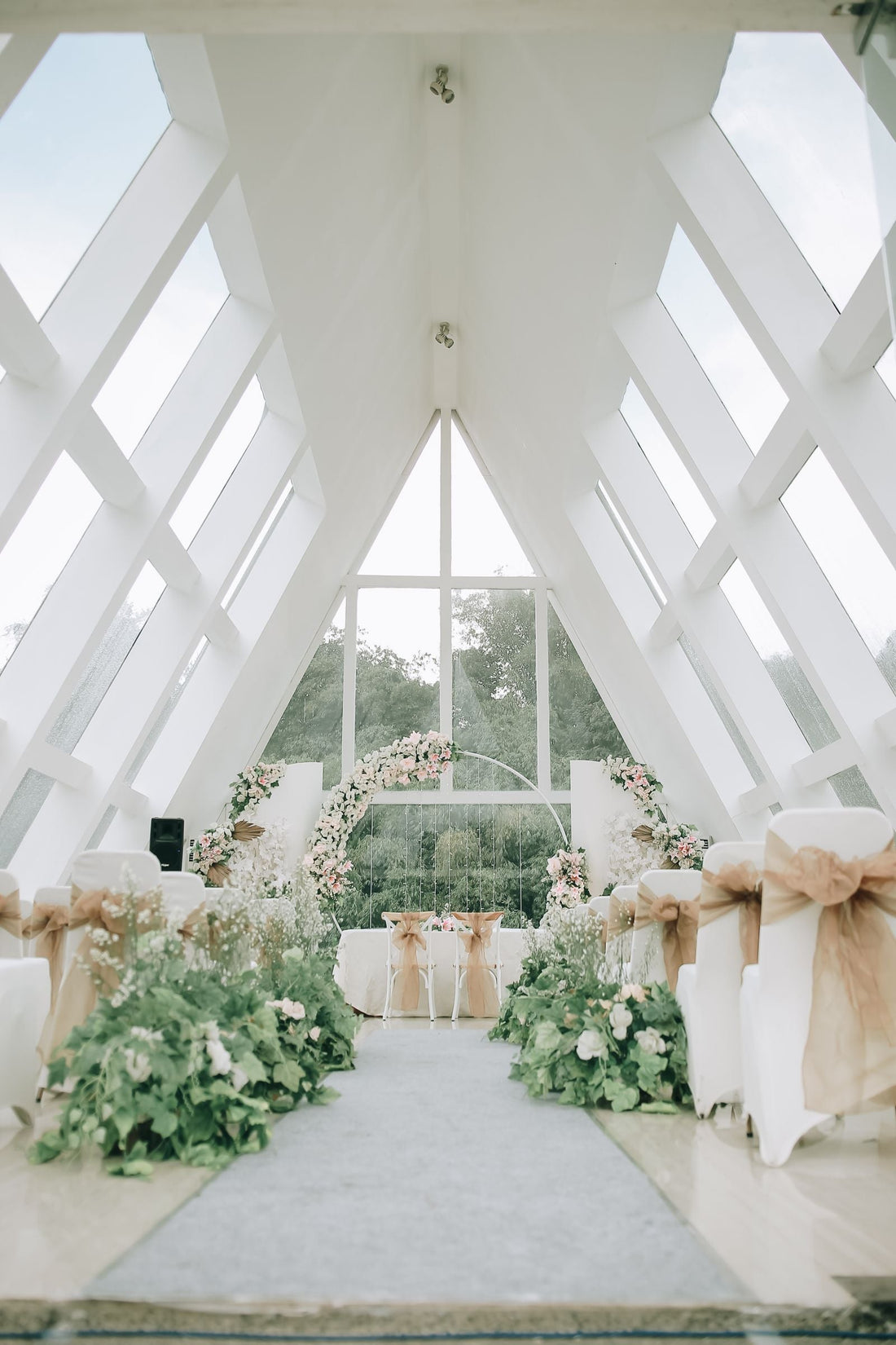 Wedding aisle in a bright modern venue; editorial inspiration photo, not a Rosy Flower Wall product or client event.