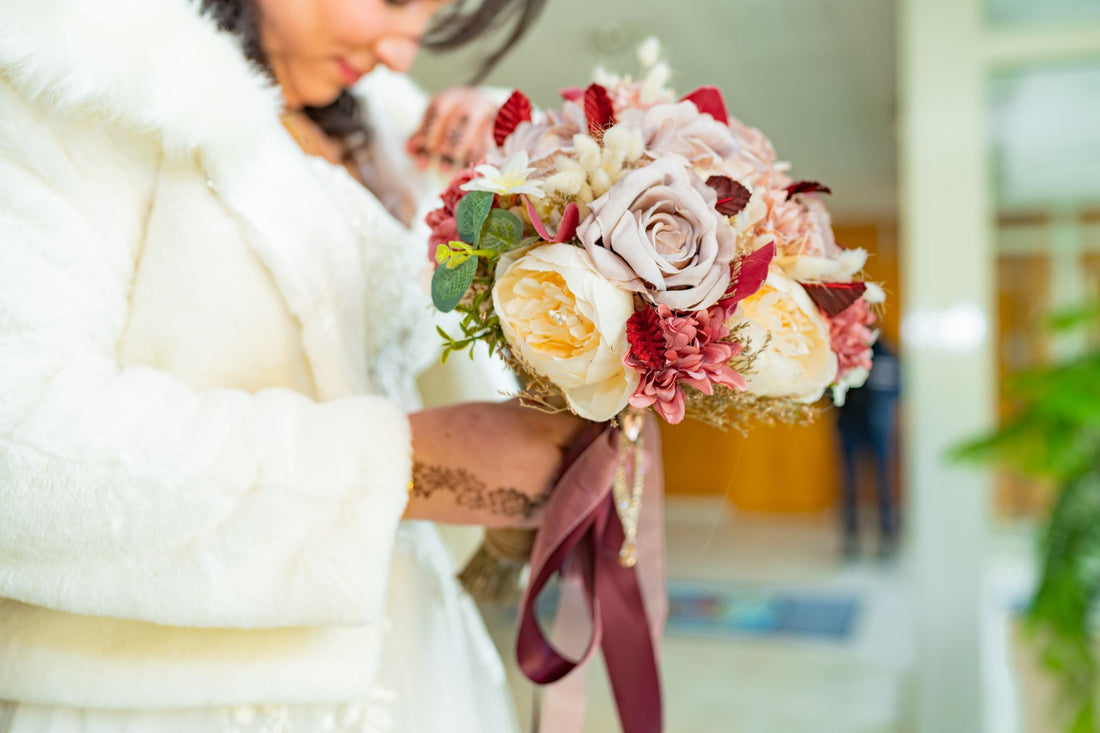 Bride holding a floral wedding bouquet with ribbons