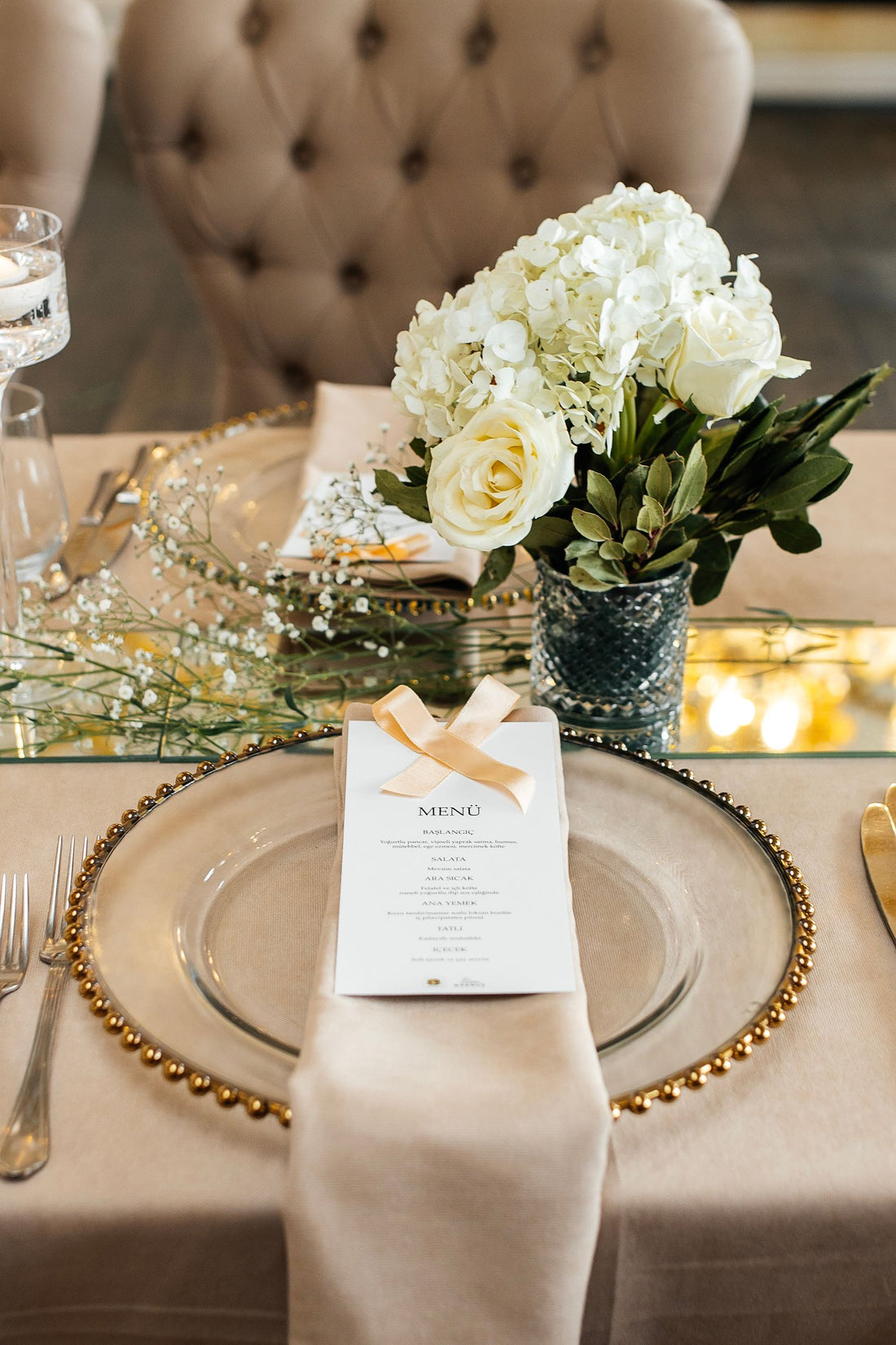 Wedding table setting with a white floral centerpiece and elegant decor
