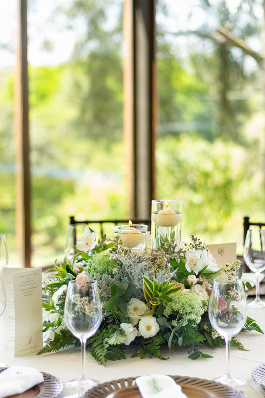 Wedding table setting with floral centerpiece, candles, and tableware