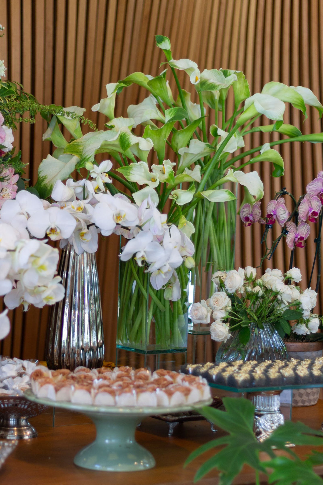 Wedding floral arrangements and desserts arranged on a reception table