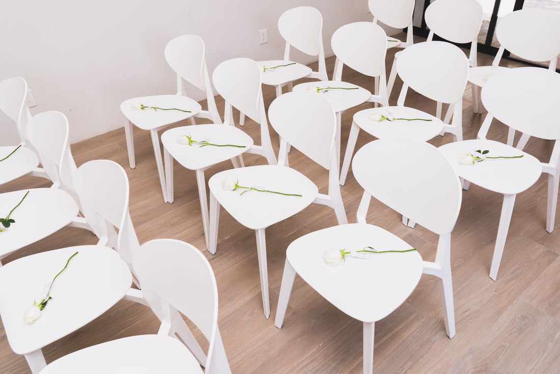 Minimalist wedding ceremony seating with white chairs and delicate flowers