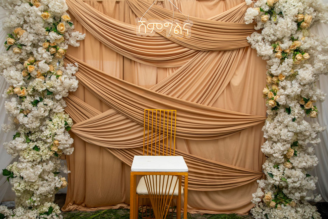 Wedding backdrop with floral arrangements and draped fabric