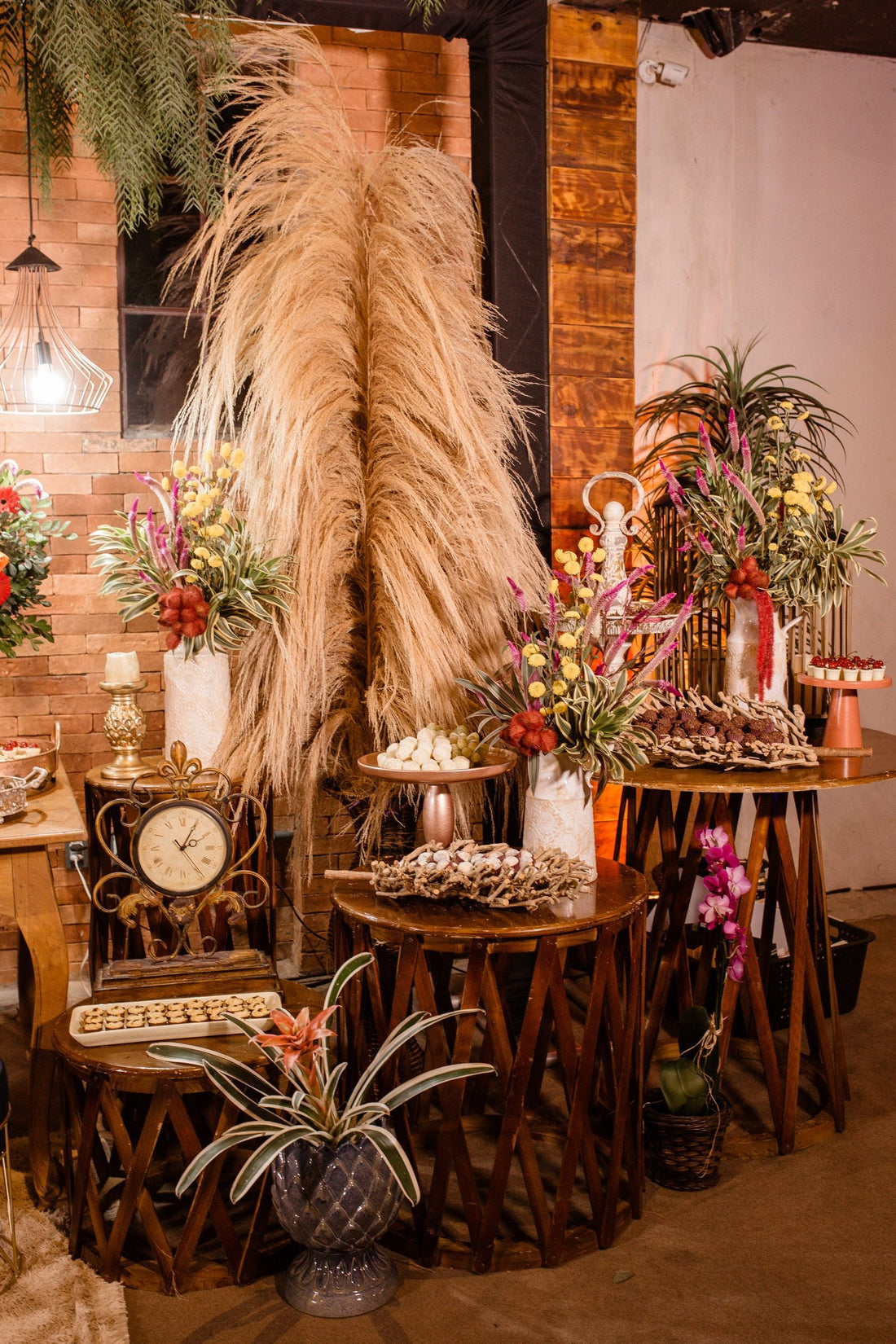 Rustic wedding reception display with warm-toned flowers, greenery, candles, and vintage decor