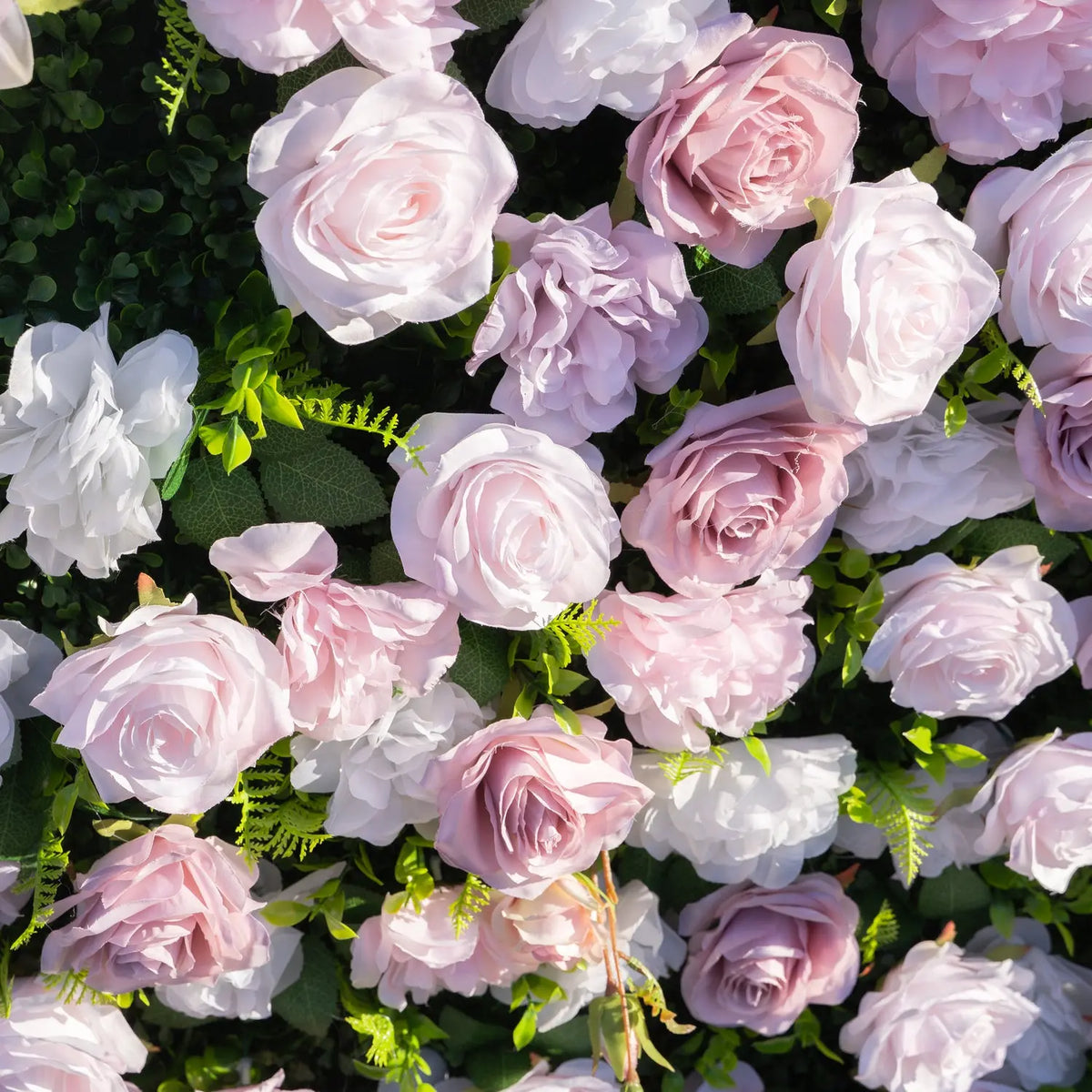 Close-up of blush pink white and mauve roses with greenery