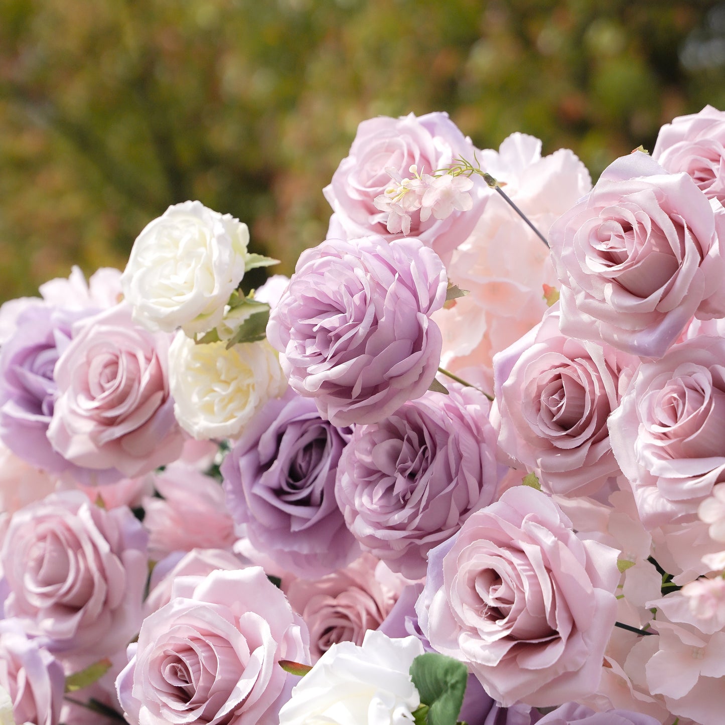 Close-up of blush, lavender and white silk flowers on the flower wall