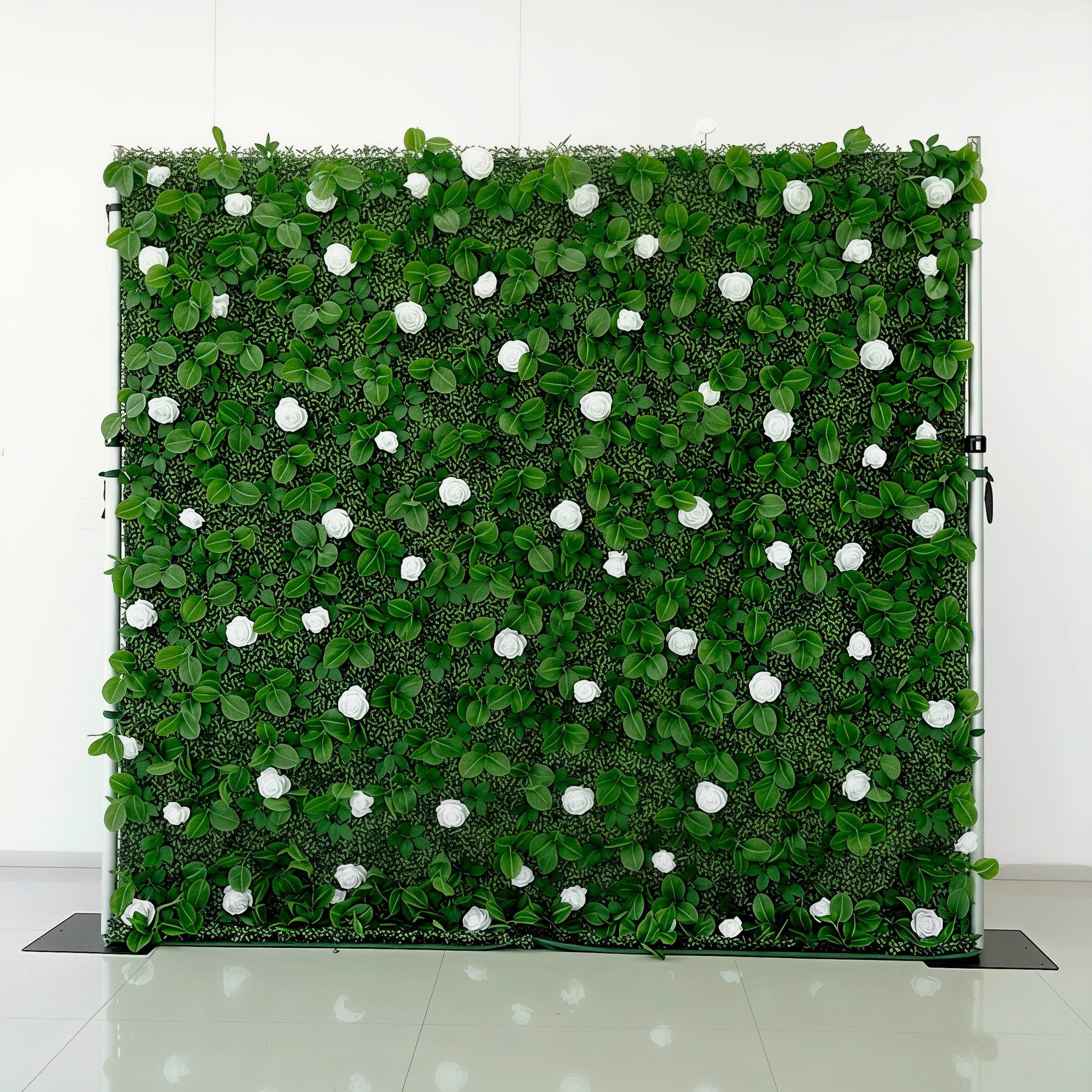 Artificial greenery wall with white flowers on a white background