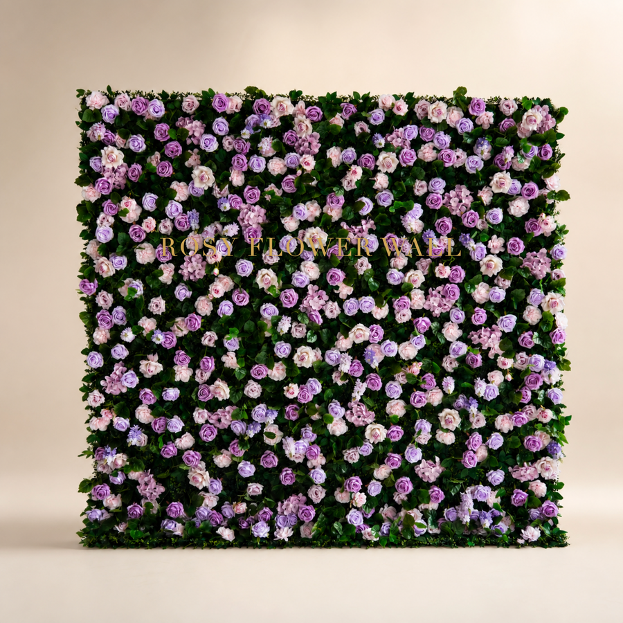 Blush lavender rose and greenery flower wall backdrop in warm ivory studio with gold Rosy Flower Wall logo