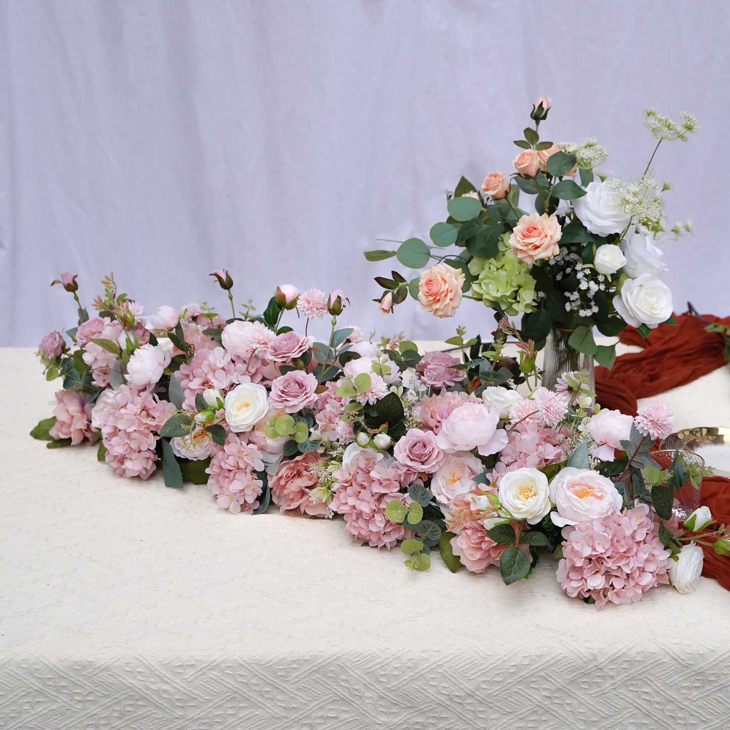 Blush pink hydrangea and rose artificial flower runner on a neutral studio table