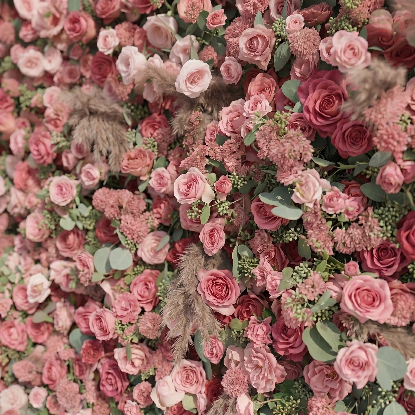 Close-up of dusty rose pink flowers and pampas grass wall