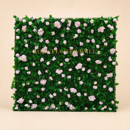 Pink rose and greenery flower wall on warm studio background with gold Rosy Flower Wall logo