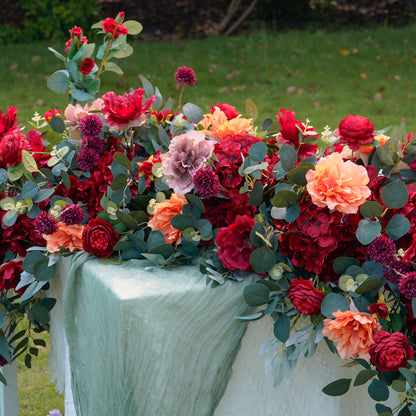 Close-up of red coral and eucalyptus wedding flower runner