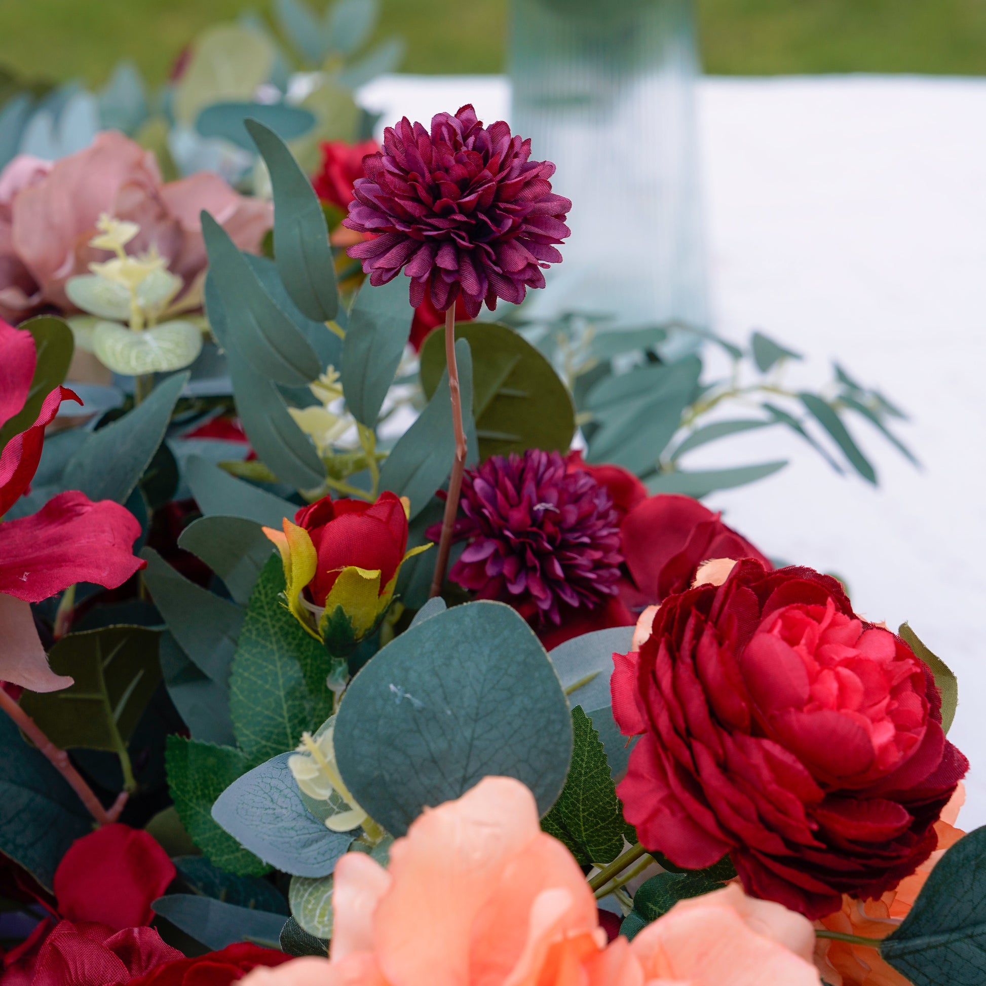 Burgundy pom flower and greenery detail