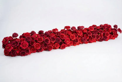 Long red rose artificial flower runner on a warm white studio background