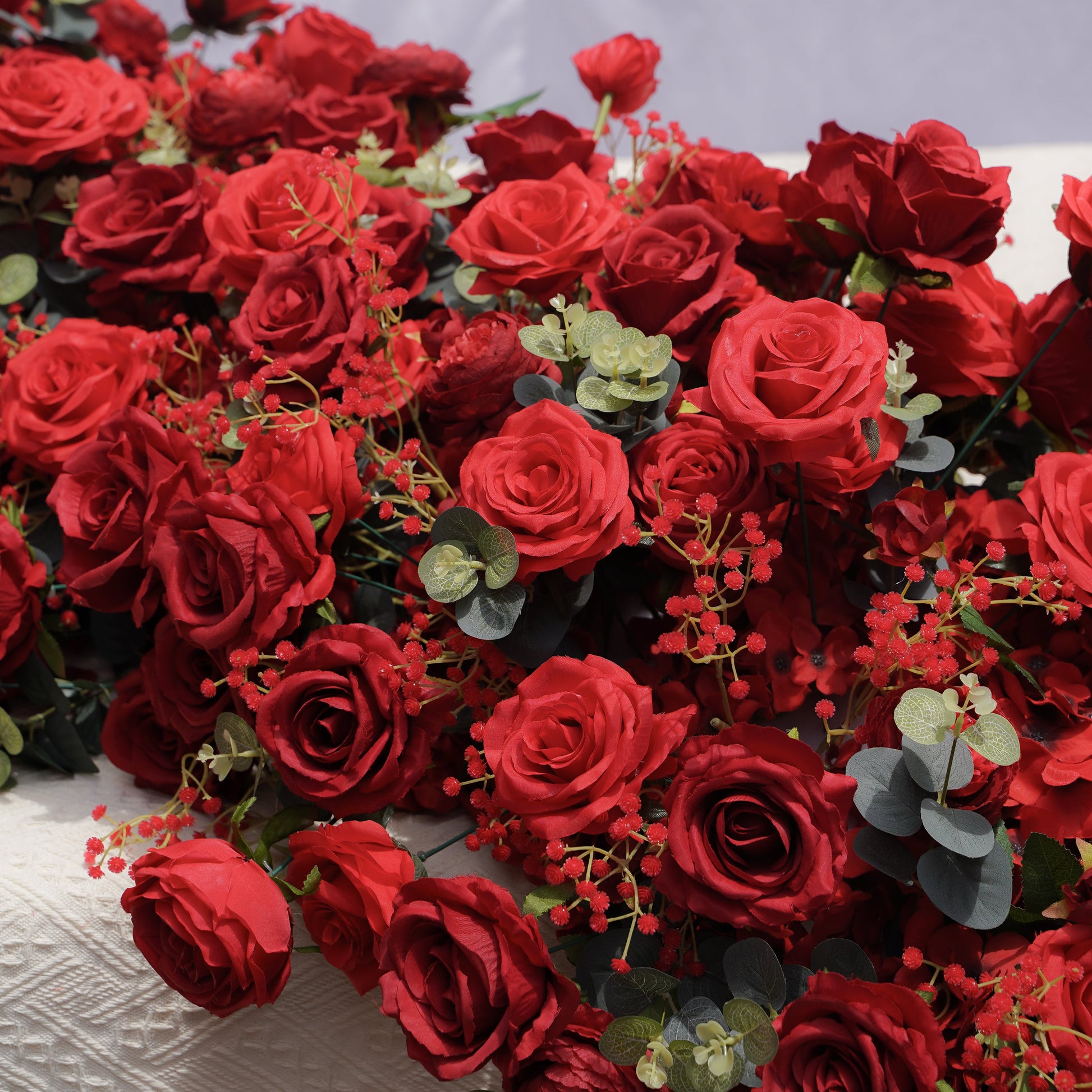 Close-up detail of red roses anemones filler flowers and eucalyptus