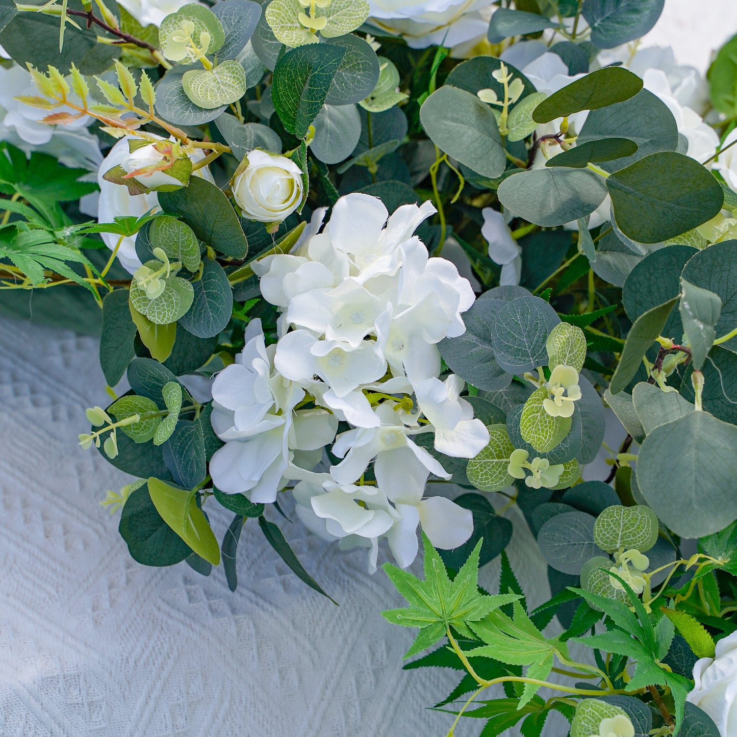 Detailed white rose hydrangea and greenery arrangement
