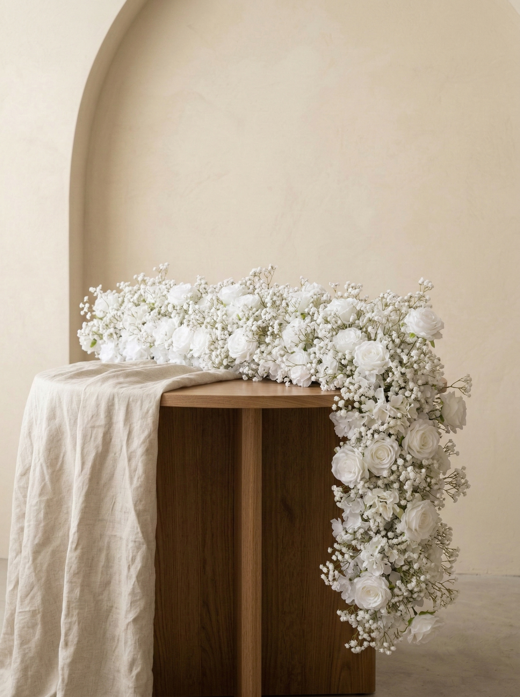 White rose and baby's breath artificial flower runner in a warm neutral studio