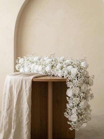 White rose and baby's breath artificial flower runner in a warm neutral studio