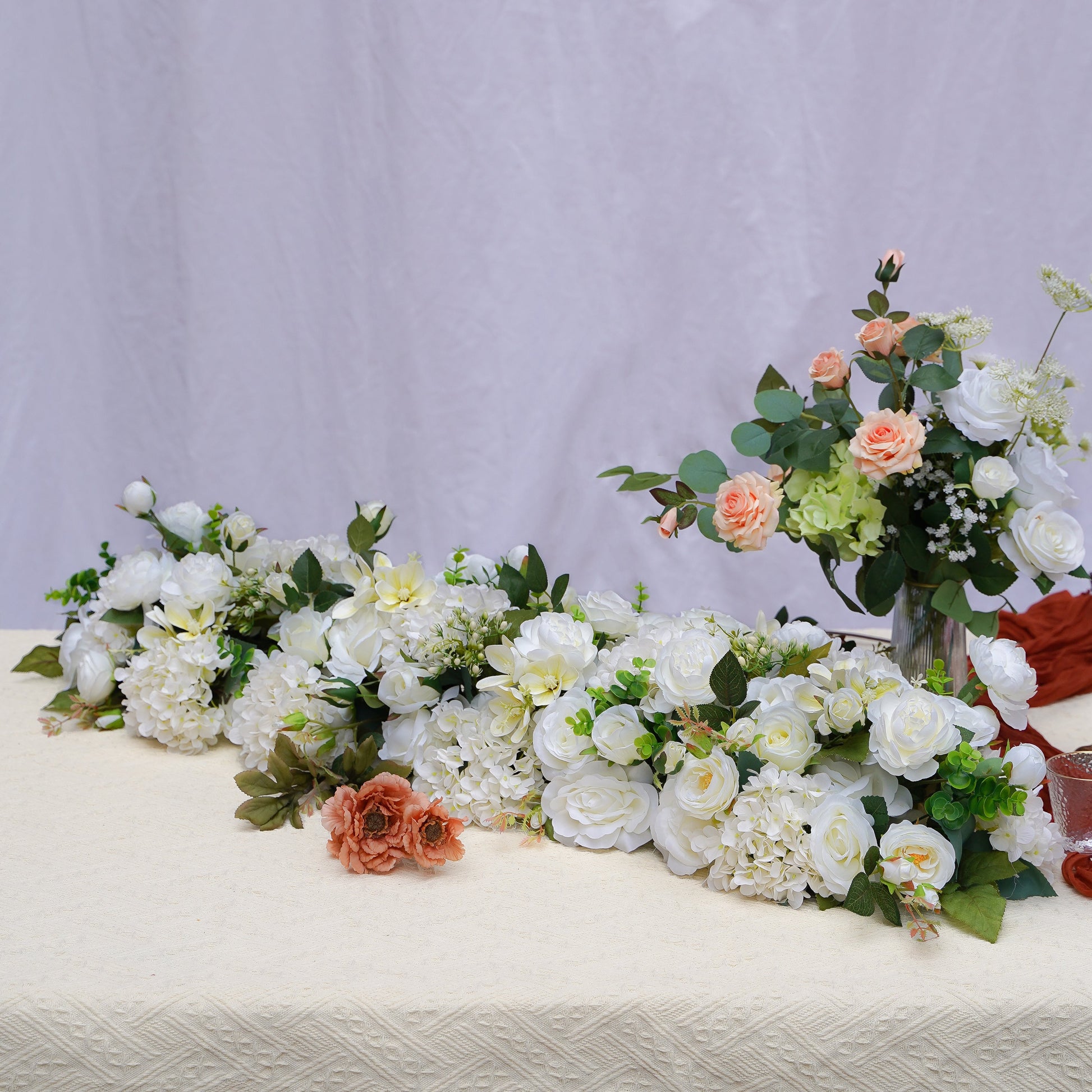 White rose and hydrangea artificial flower runner on a warm neutral table